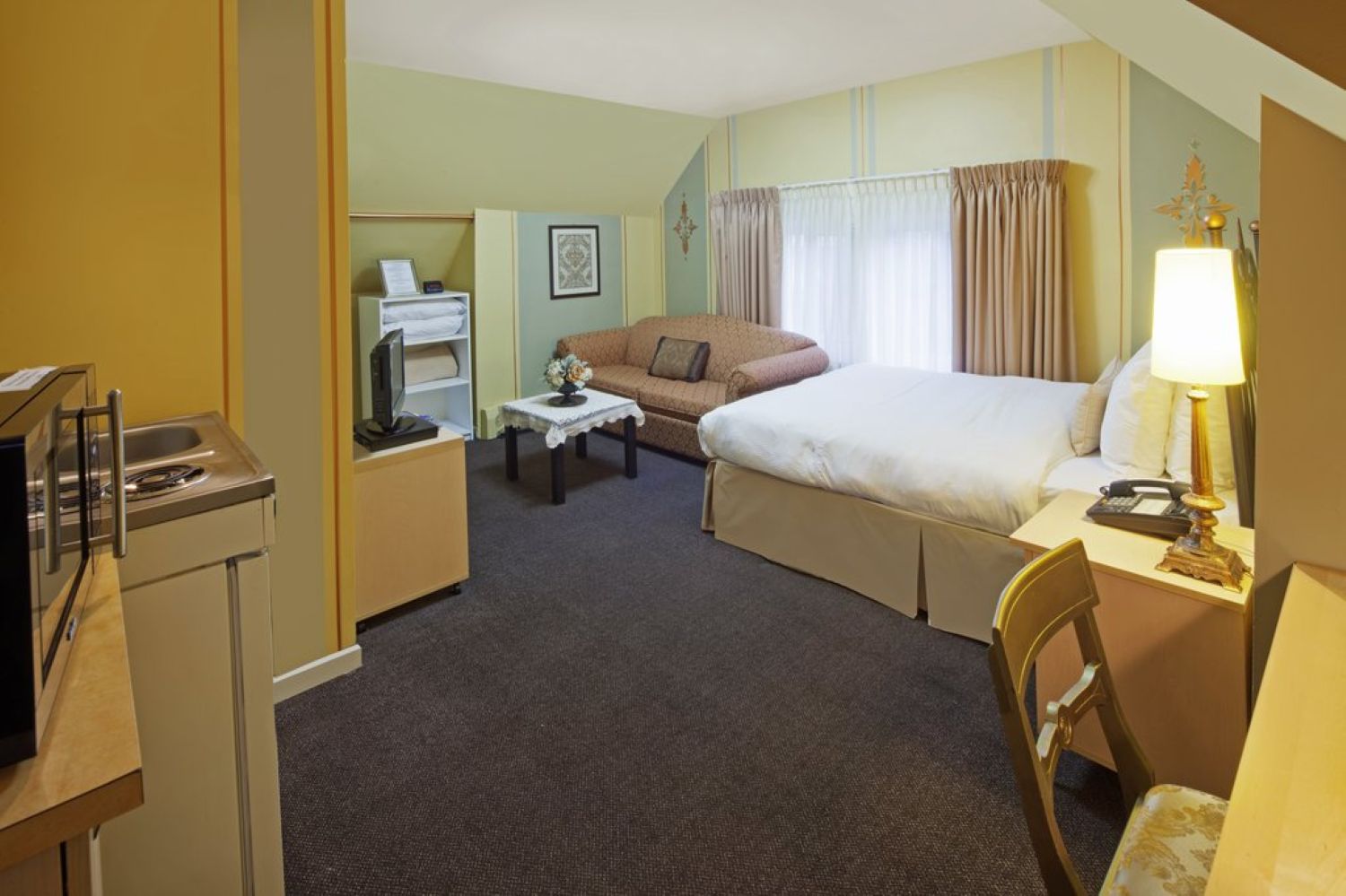 Studio room on the third floor with a bed, sofa, TV, and microwave